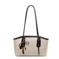 White handbag with black handle and decorative elements on a white background
