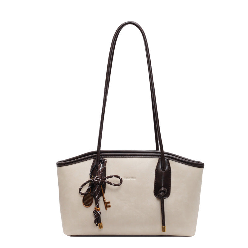 White handbag with black handle and decorative elements on a white background